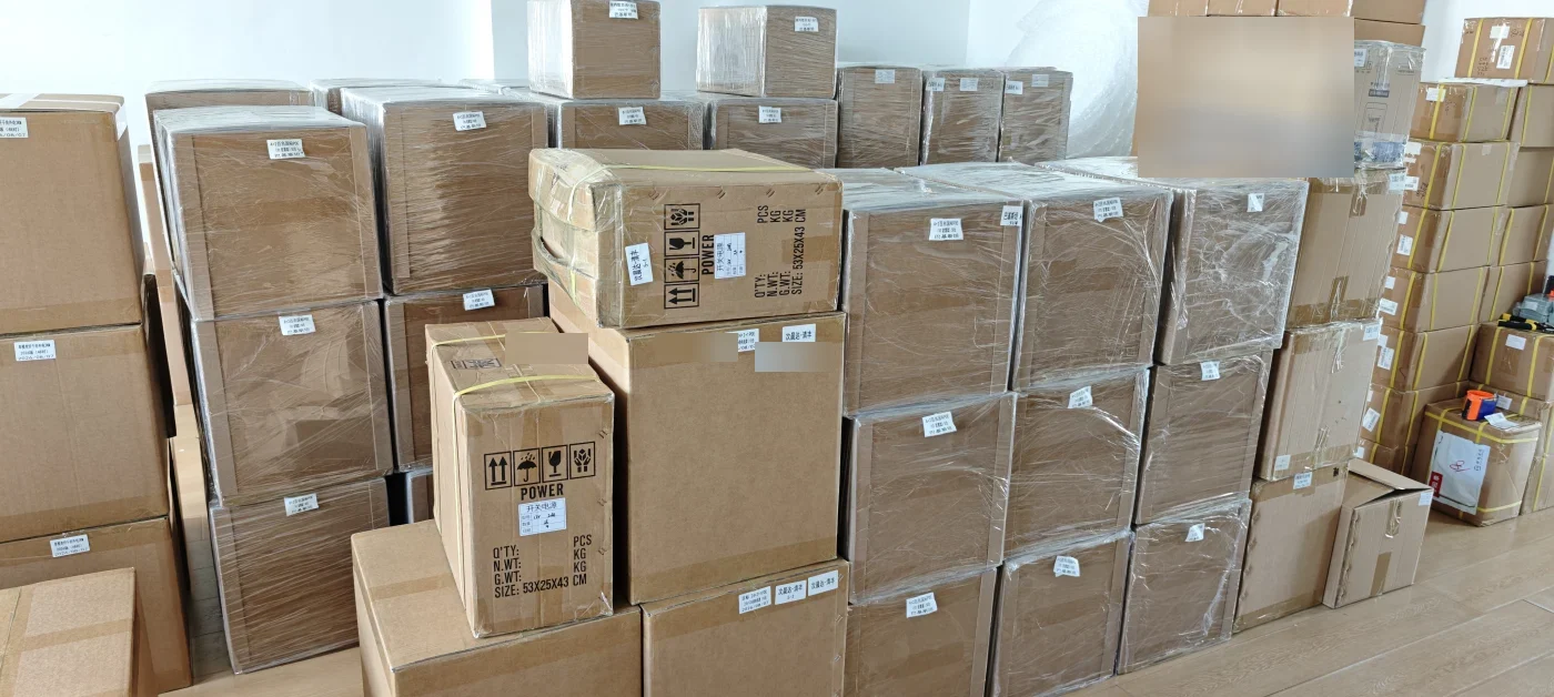 Cartons of FE PoE switches and power supplies packed and wrapped for shipment to Pakistan